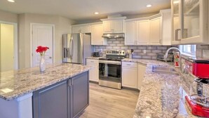 A modern kitchen with granite countertops, stainless steel appliances, and white cabinetry. - Upscale House for 17 with Firepit & Lovely Yard (Star)