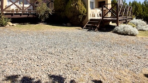 A modern building with a gravel driveway, outdoor seating area, and a covered patio. - Arroyo Suite House (Nono)