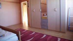 A bedroom with a bed, a wardrobe, and a mirror. - Apartment Angela (Bad Sachsa)
