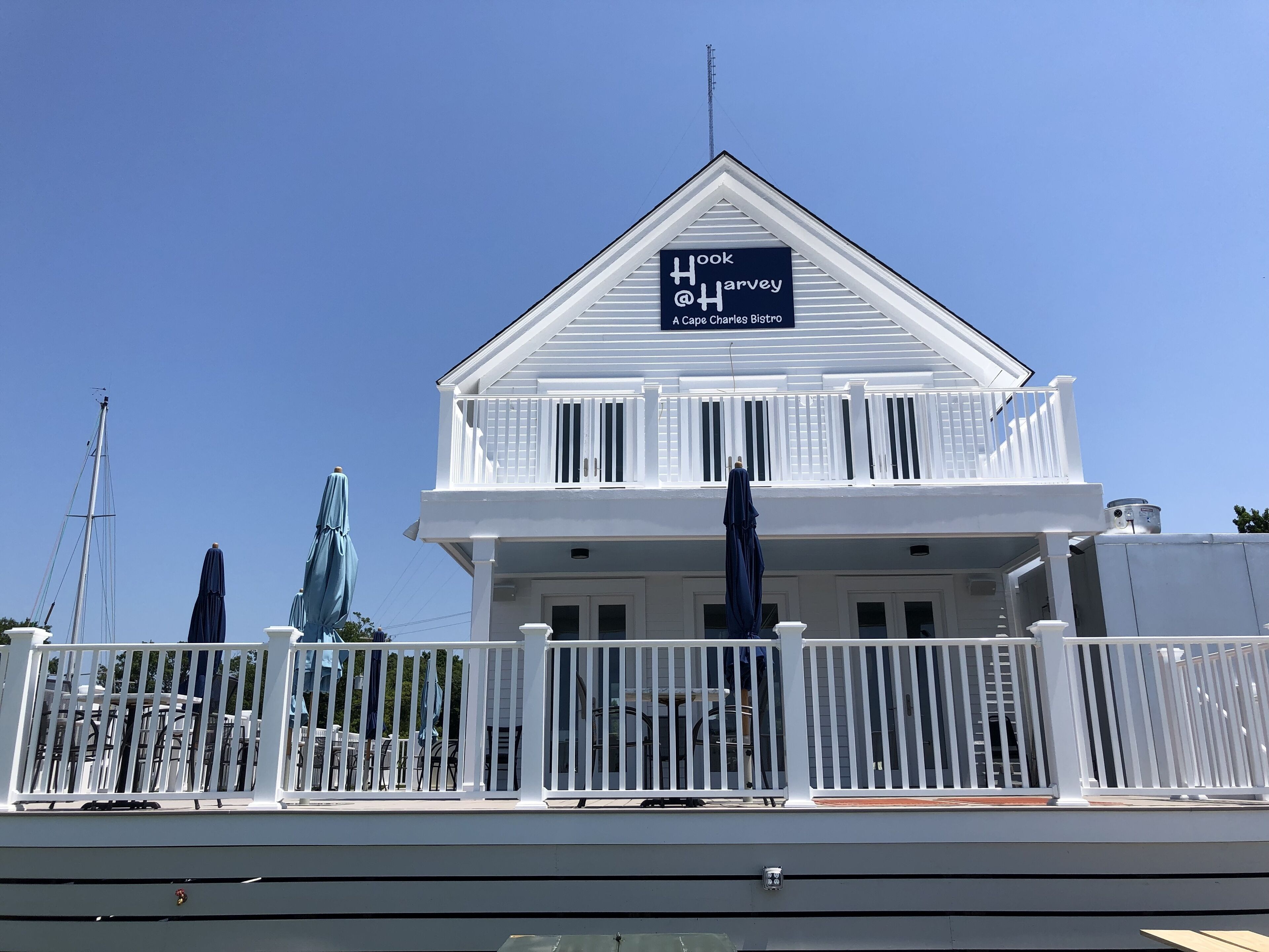 A white building with a sign reading "Hook Harvey A Cape Charles Bistro".