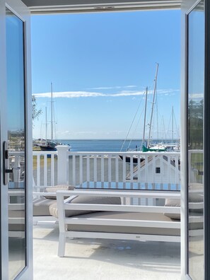 A view from a balcony with a white railing, overlooking a marina with several sailboats docked. - The Crows Nest. <br>Sunsets at the Harbor. Enjoy bird’s eye view. Unique location! (Cape Charles)
