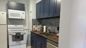 A compact kitchen with a microwave, oven, and dishwasher. - Beachfront 1BR/1BA/Ocean View Patio and Free Parking for 1 Compact Car (Hollywood)