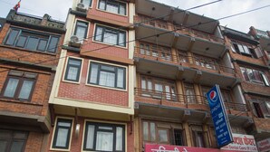 A multi-story building with various shops on the ground floor, including a hotel and a dental care center. - Hotel Tryst (Bhaktapur)
