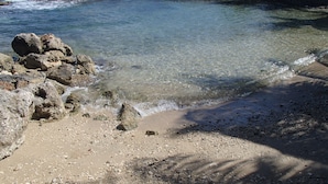 Ein felsiger Strand mit klarem Wasser und großen Felsen.