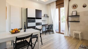 Una cocina moderna con comedor, una pequeña mesa y sillas, y un frutero en la encimera.