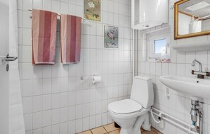 Bathroom features a white toilet, sink, and mirror, with a decorative frame and striped towels.