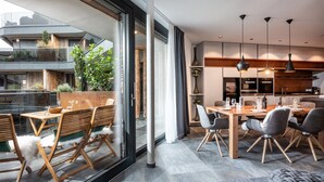 Un espace de restauration moderne doté d’une grande fenêtre, de meubles en bois et d’un éclairage suspendu.