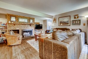 A cozy living room with a fireplace, leather sofa, and wooden accents. - Kick back in our Keystone getaway! Near Slopes (Keystone)