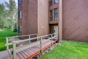 A modern building with a wooden exterior, a small porch, and a sign indicating a sauna.