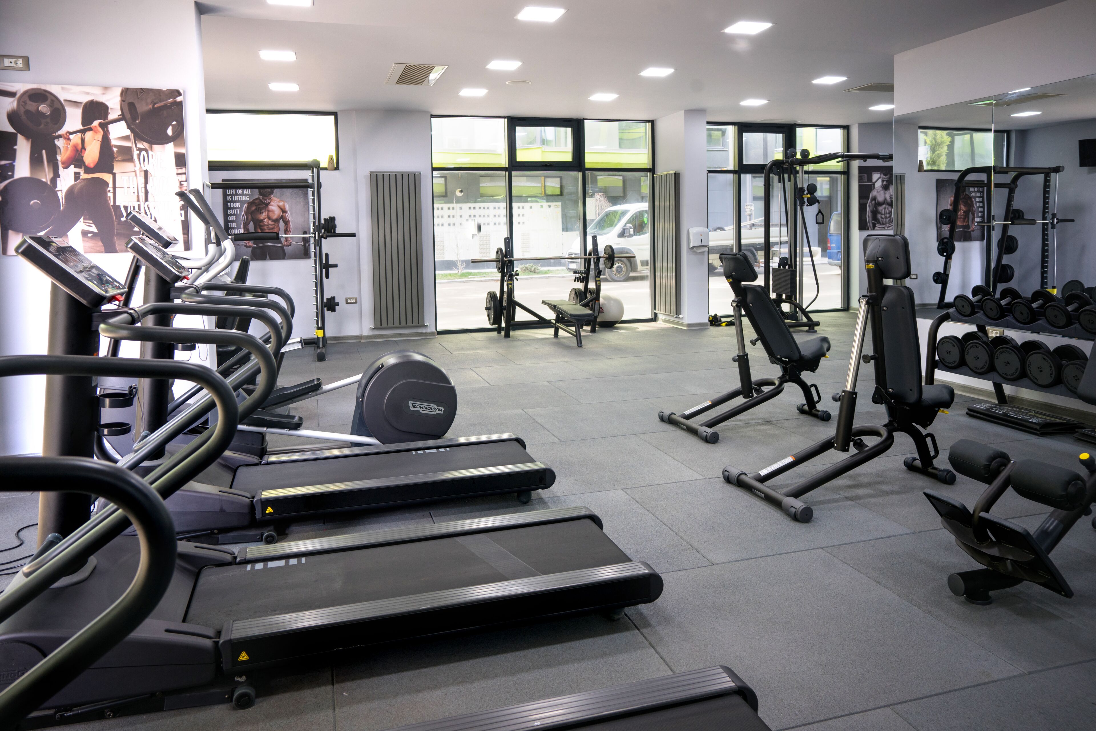 Ett gym med löpband, styrketräningsmaskiner och hantlar.