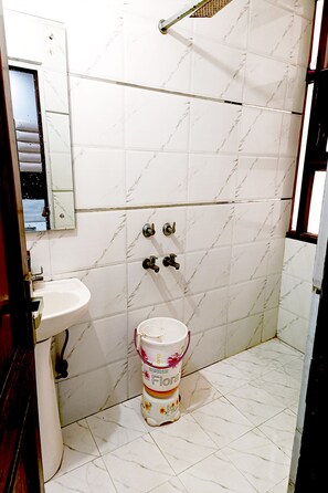 A bathroom with a white sink, a toilet, and a mirror. - Hotel Crystal Deluxe at New Delhi Railway Station (New Delhi)