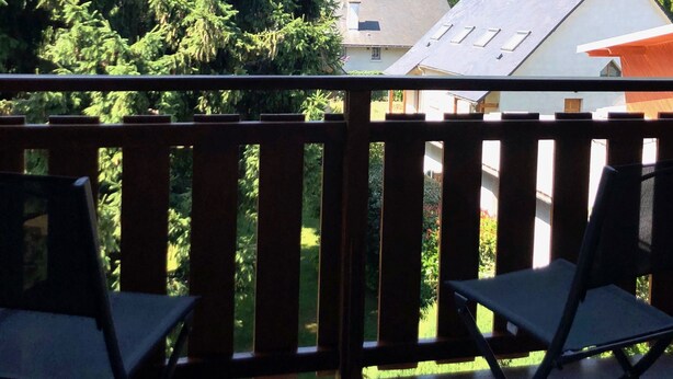 Ein Balkon mit zwei Stühlen und Blick auf eine Kirche, ferner ein Berg.