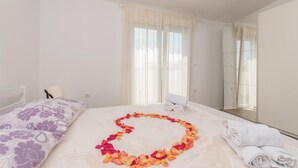 Une chambre d’hôtel avec un lit, une chaise et un miroir.