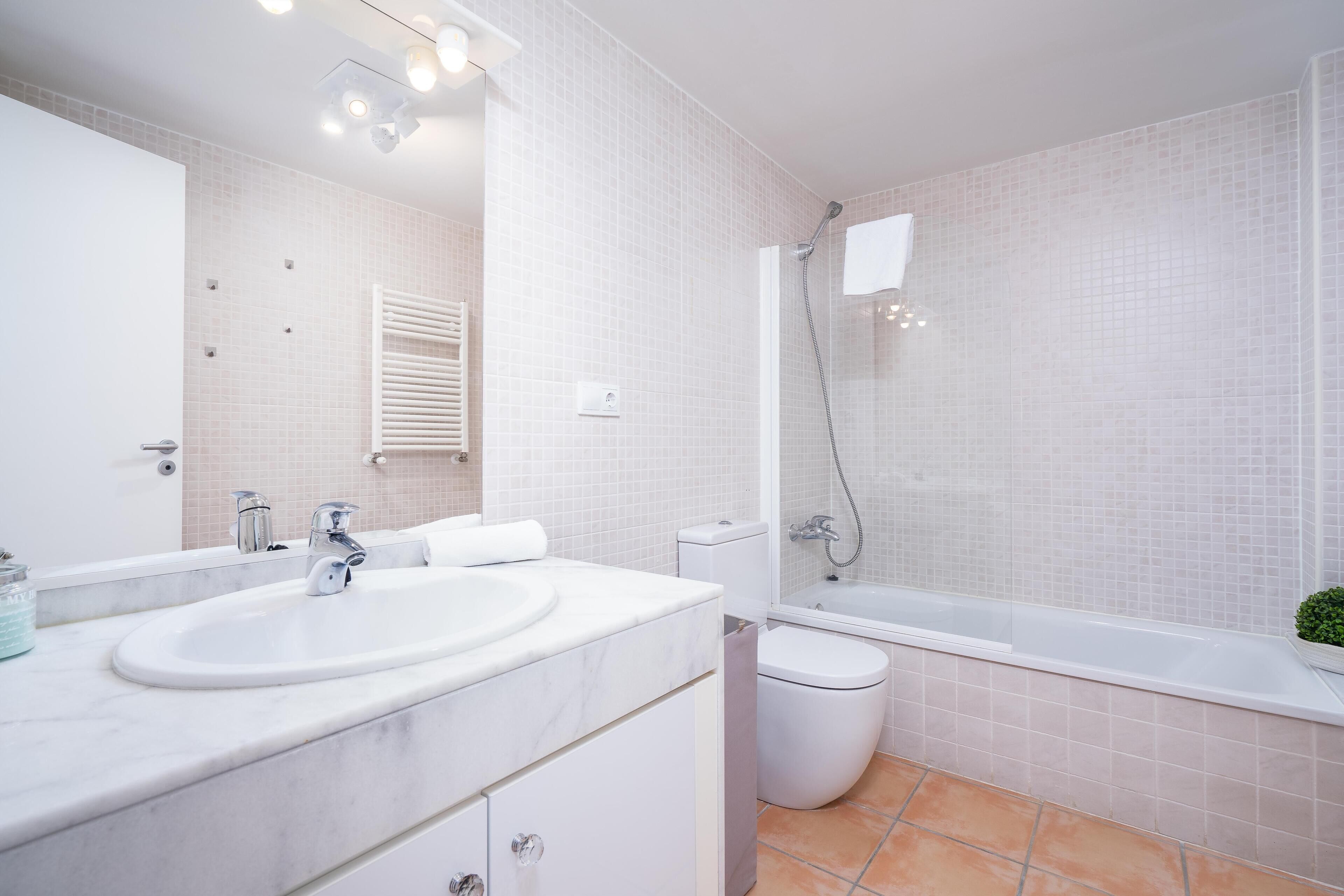 A modern bathroom with a large sink, toilet, and bathtub.