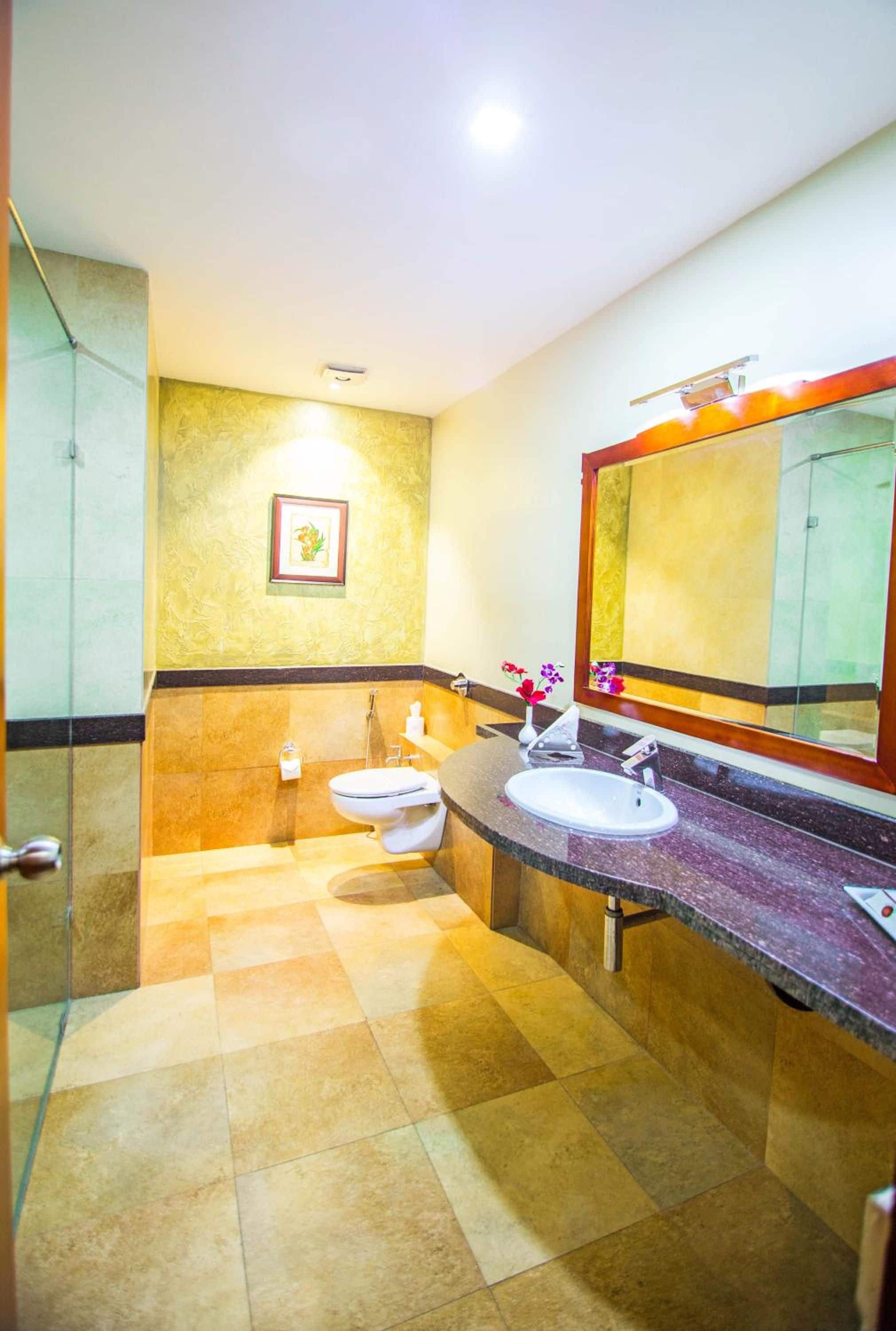 A bathroom with two sinks, a toilet, and a shower.