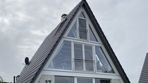 Ein dreieckiges Gebäude mit großen Fenstern und einer Satellitenschüssel.