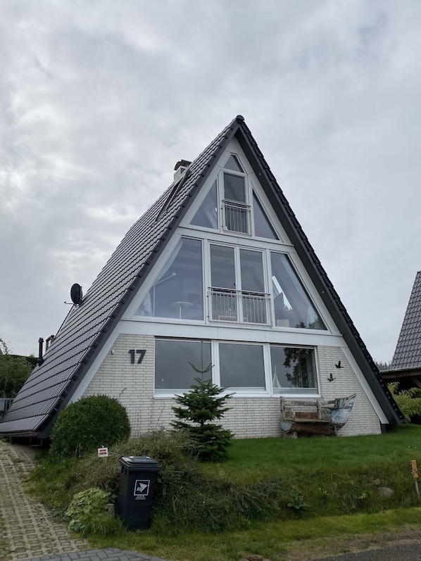 Un bâtiment de forme triangulaire, doté de grandes fenêtres et d’une antenne parabolique.