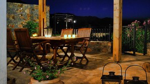 An outdoor patio with a wooden pergola, stone wall, and a table with chairs. There are two lanterns and a potted plant with flowers. - Spacious villa with private pool and sea view, just 150 meters from the sea (Istro)