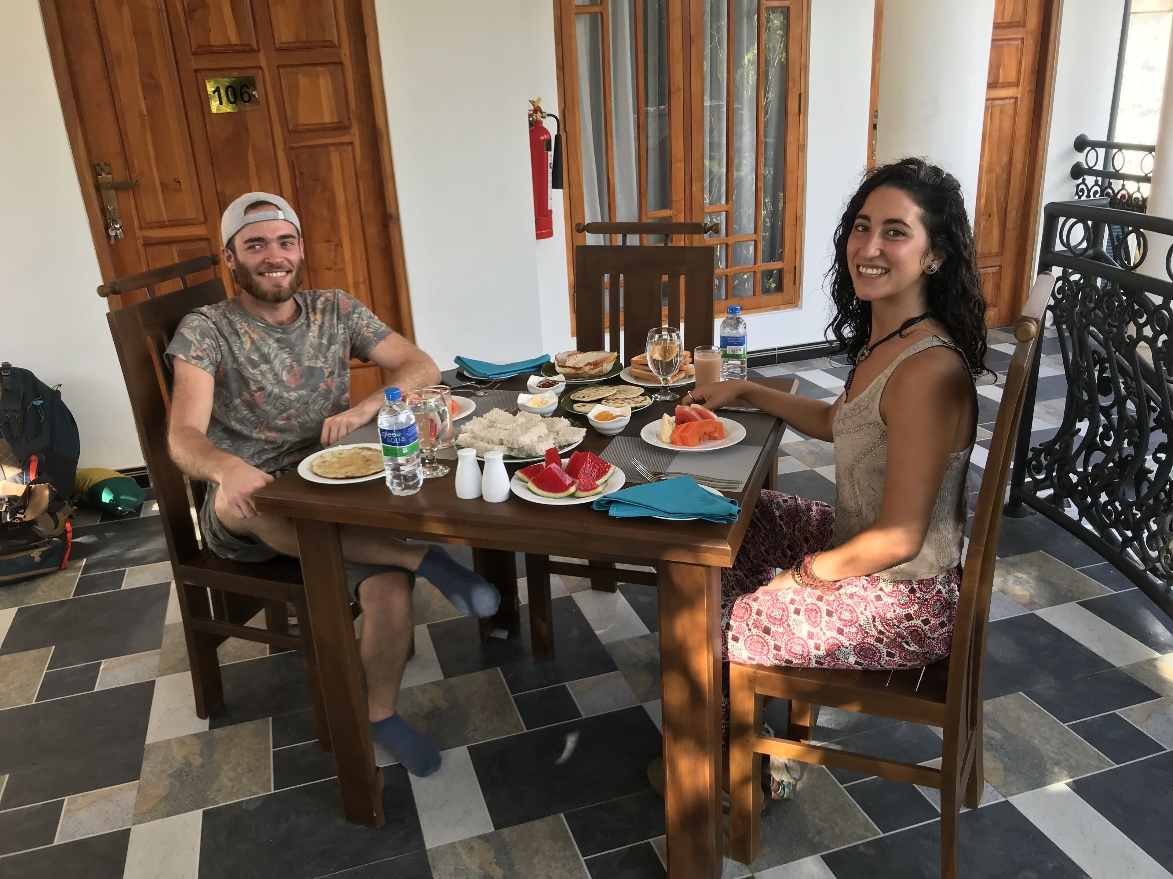 Une table à manger avec des assiettes remplies de nourriture, une bouteille d’eau et un extincteur.