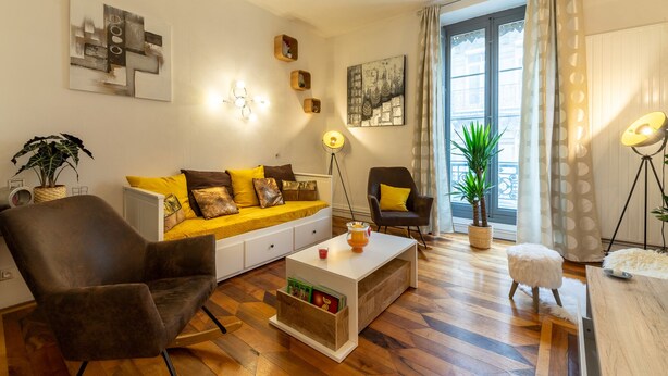 Una sala de estar moderna con un sofá, sillones, una mesa de centro y una lámpara de pie.