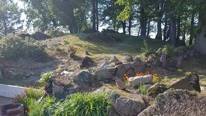 A natural outdoor area with large rocks, some greenery, and a small water feature. - GITE LE COIN with swimming pool (Bonnemain)