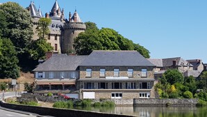 A stone building with a sign reading "HOTEL RESTAURANT DE LA" near a body of water. - GITE LE COIN with swimming pool (Bonnemain)