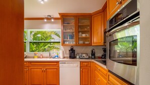A kitchen with wooden cabinets, a stainless steel oven, and a dishwasher.
