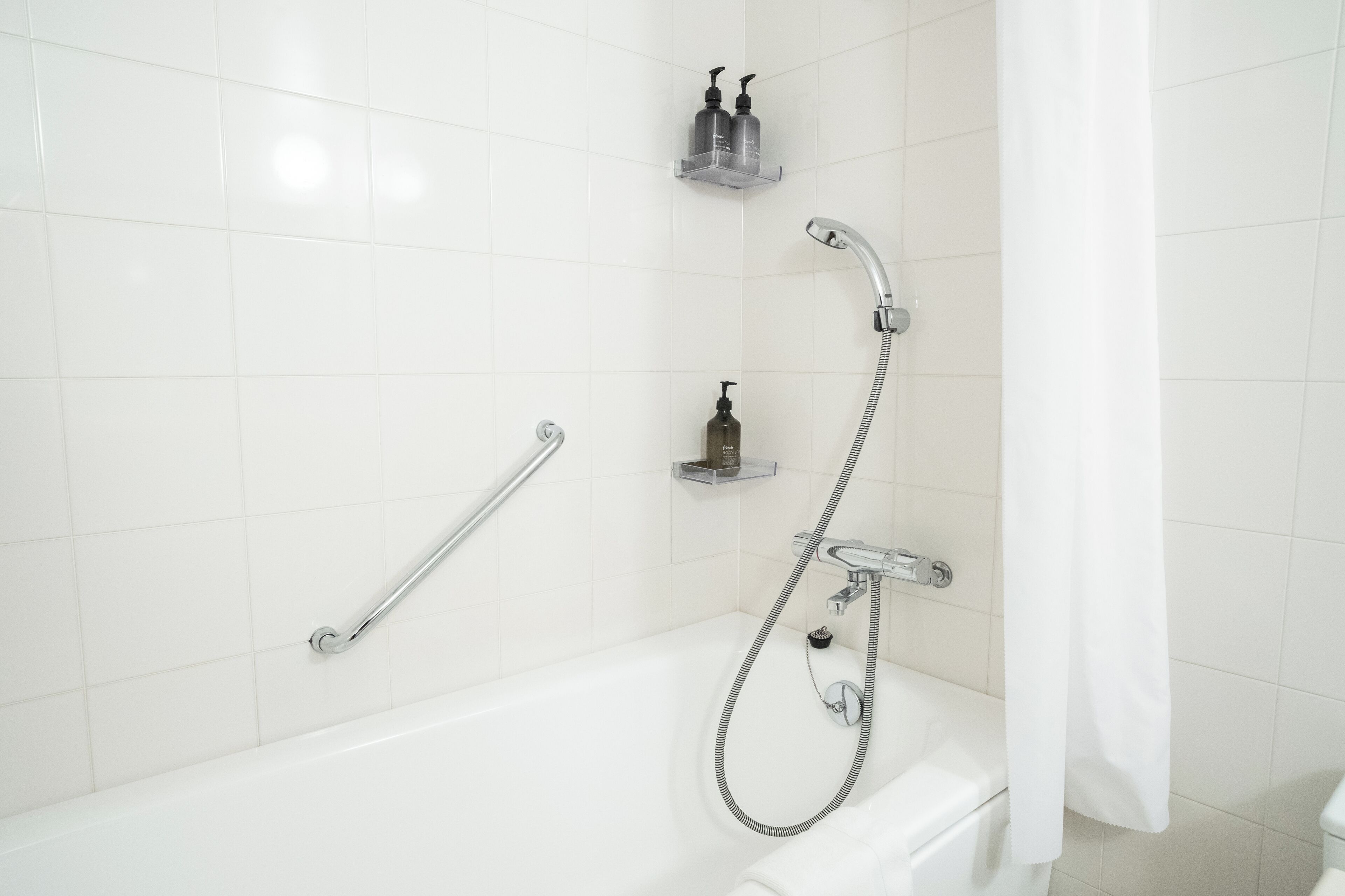 signature suite (non-smoking) | bathroom | combined shower/bathtub, eco-friendly toiletries, hair dryer, slippers