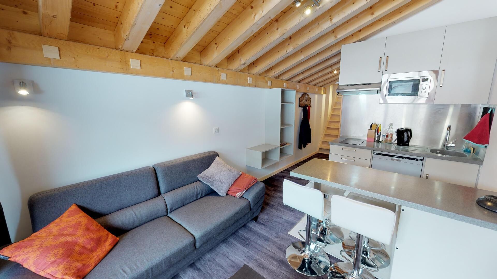 A modern kitchen with a microwave, sink, and stainless steel appliances.