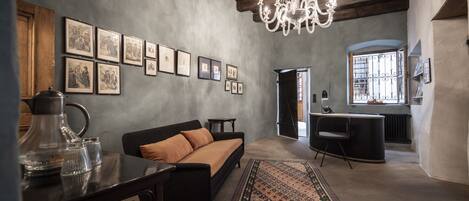 A cozy living room with a sofa, coffee table, and chandelier.