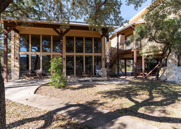 A building with large windows, a covered patio area, and a stone structure.