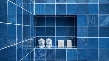 Een aparte badkuip en douche, een diep bad, een regendouche