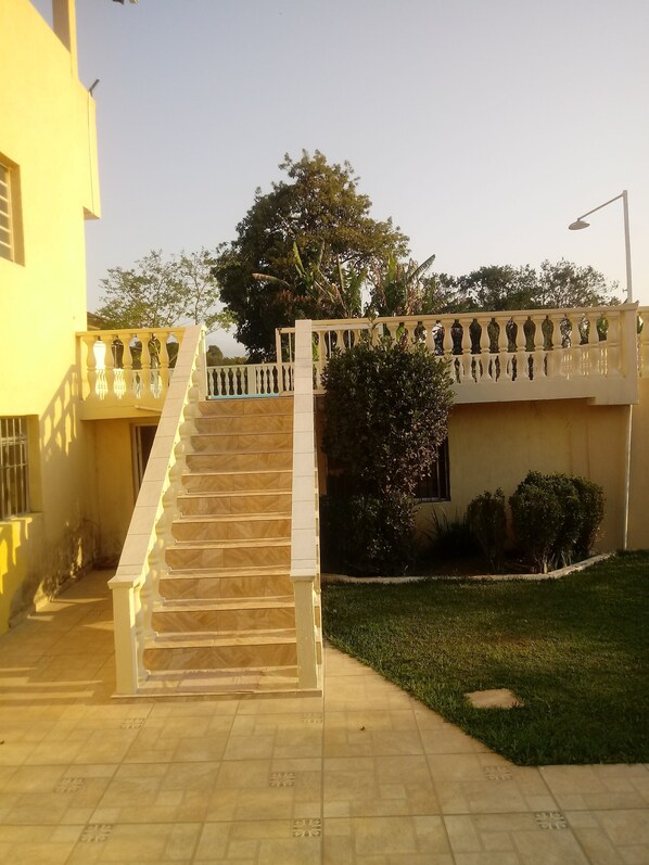 A staircase leading to a building with a yellow exterior, a decorative railing, and a well-maintained lawn. - Rent a country house in Ibiúna (Ibiúna)