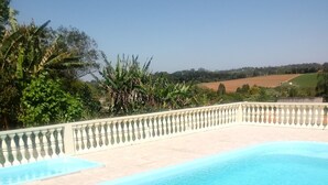 Une piscine dotée d’une terrasse carrelée et d’une rambarde décorative.
