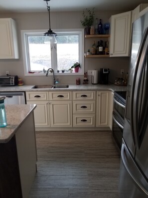 Enjoy cooking in this well-equipped kitchen with a refrigerator, oven, and microwave.