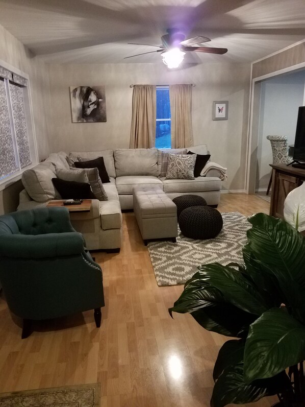 Relax in this stylish living room with a large L-shaped sofa, armchair, and ottoman.