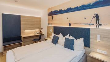 Een moderne hotelkamer met een groot bed, een bureau en een televisie aan de muur.