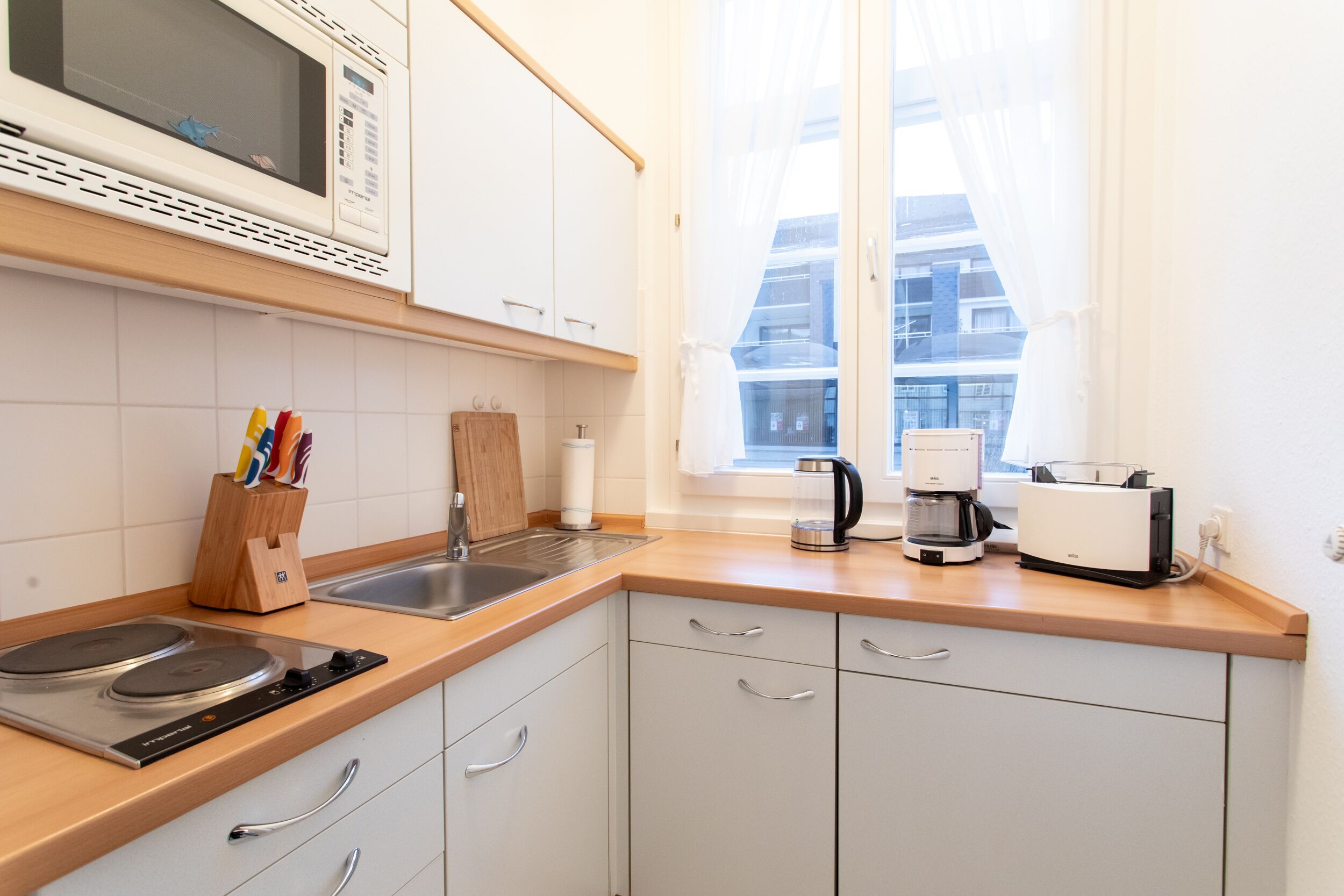 Une cuisine moderne équipée d’un four à micro-ondes, d’une cuisinière, d’un évier et d’une machine à café.