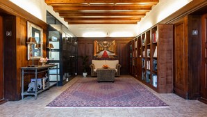 A hallway with wooden walls, a central seating area with a rug, and bookshelves on both sides. - Altes Rathaus Hahnenklee (Goslar)