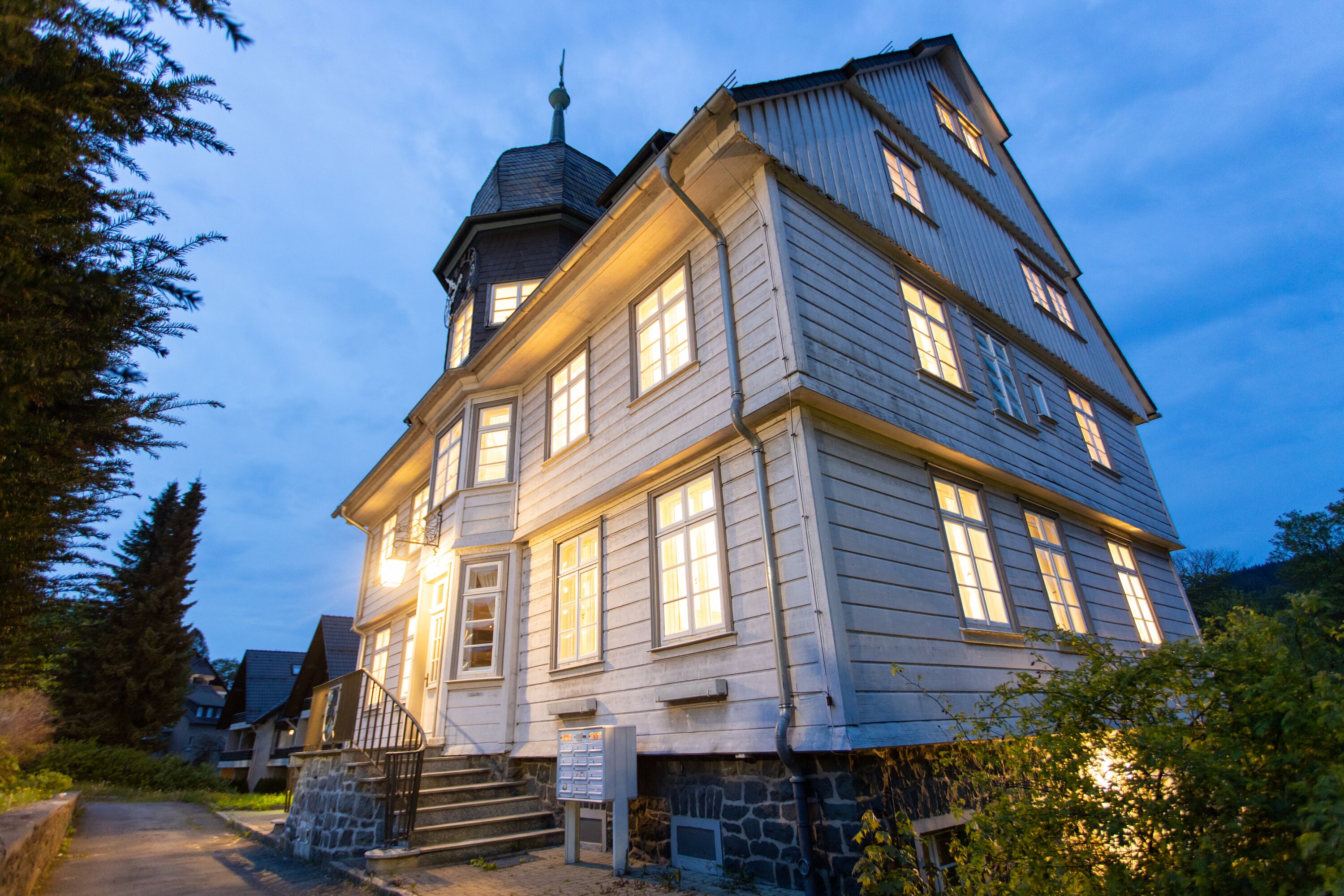 A multi-story building with a prominent tower and a stone foundation.