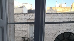 Un balcon avec des balustrades en métal blanc, une table ronde et deux chaises.