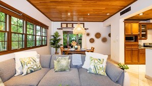 A living room with a sofa, dining table, and kitchen area.