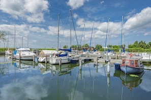 A marina with multiple boats docked, calm water, and a clear sky. - Modern vacation apartment in Loddin with garden, WLAN & barbecue - quiet, close to the beach, mod (Loddin)