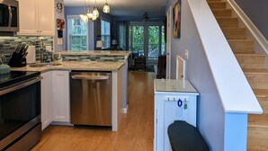 A modern kitchen with white cabinets, stainless steel appliances, and a wooden floor. - Paradise found at the Key West Golf Club! (Key West)