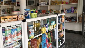 Un magasin dont les étagères sont remplies de divers produits, notamment des articles de toilette, des en-cas et des articles ménagers.