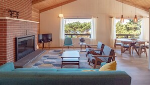 A spacious living area with a fireplace, television, and comfortable seating. - hot tub, ocean views and wood burning fireplace (Tillamook)