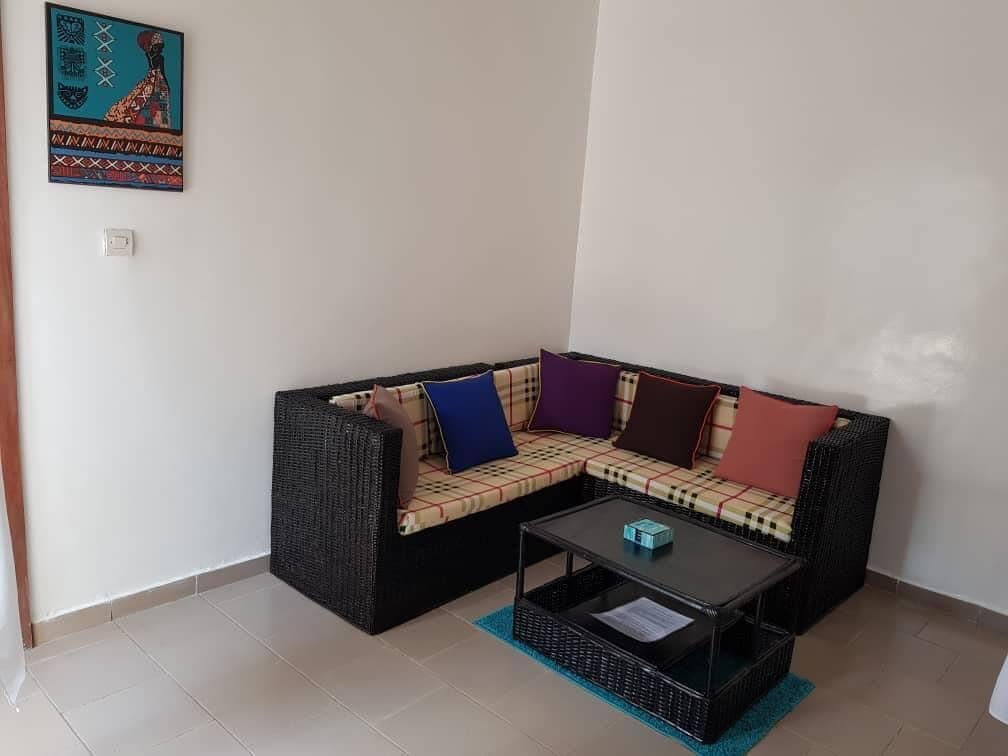 Un salón con sofá, una mesa de centro y una cesta de mimbre.