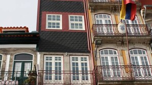 A multi-story building with balconies and a flag. - Guest House Douro (Porto)