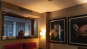 A room with a red sofa, a clear glass table, and two framed floral artworks on the wall. - Guest House Douro (Porto)