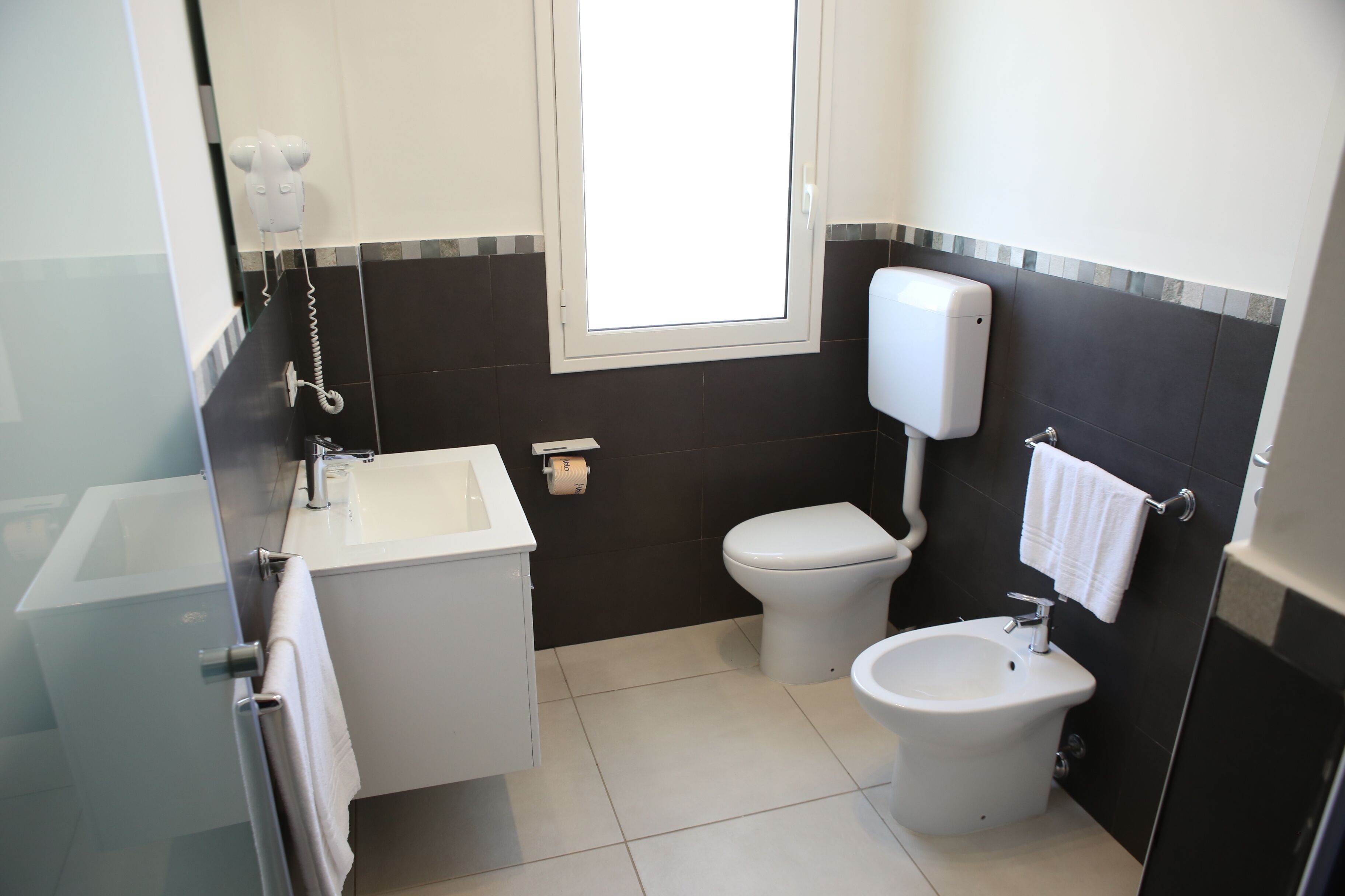 Un baño pequeño con inodoro, bidé y lavamanos.